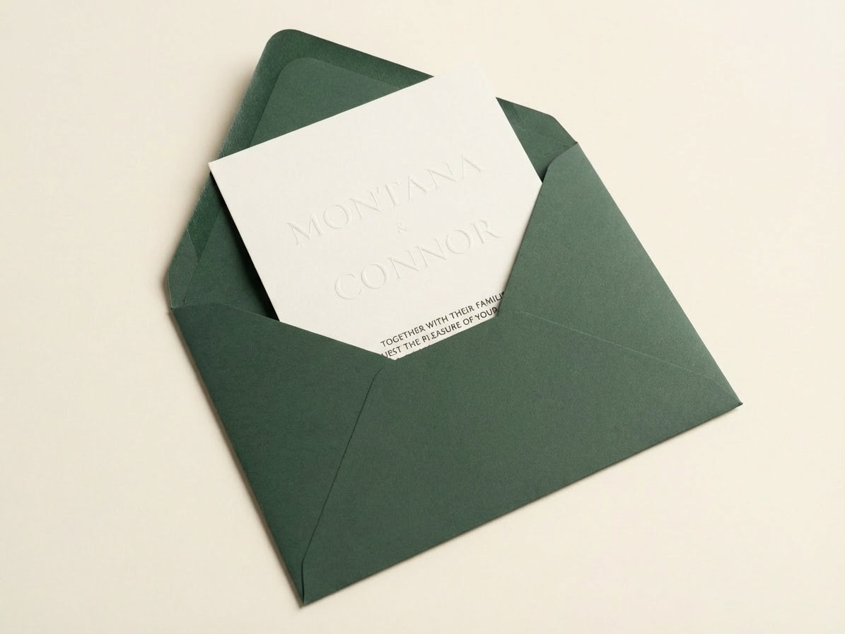 Althea embossed wedding invitation with ivory cardstock inside a deep forest green luxury envelope.